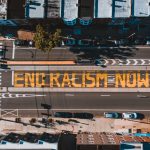 Roadway with END RACISM NOW title in town