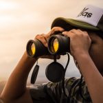 Man Looking in Binoculars during Sunset